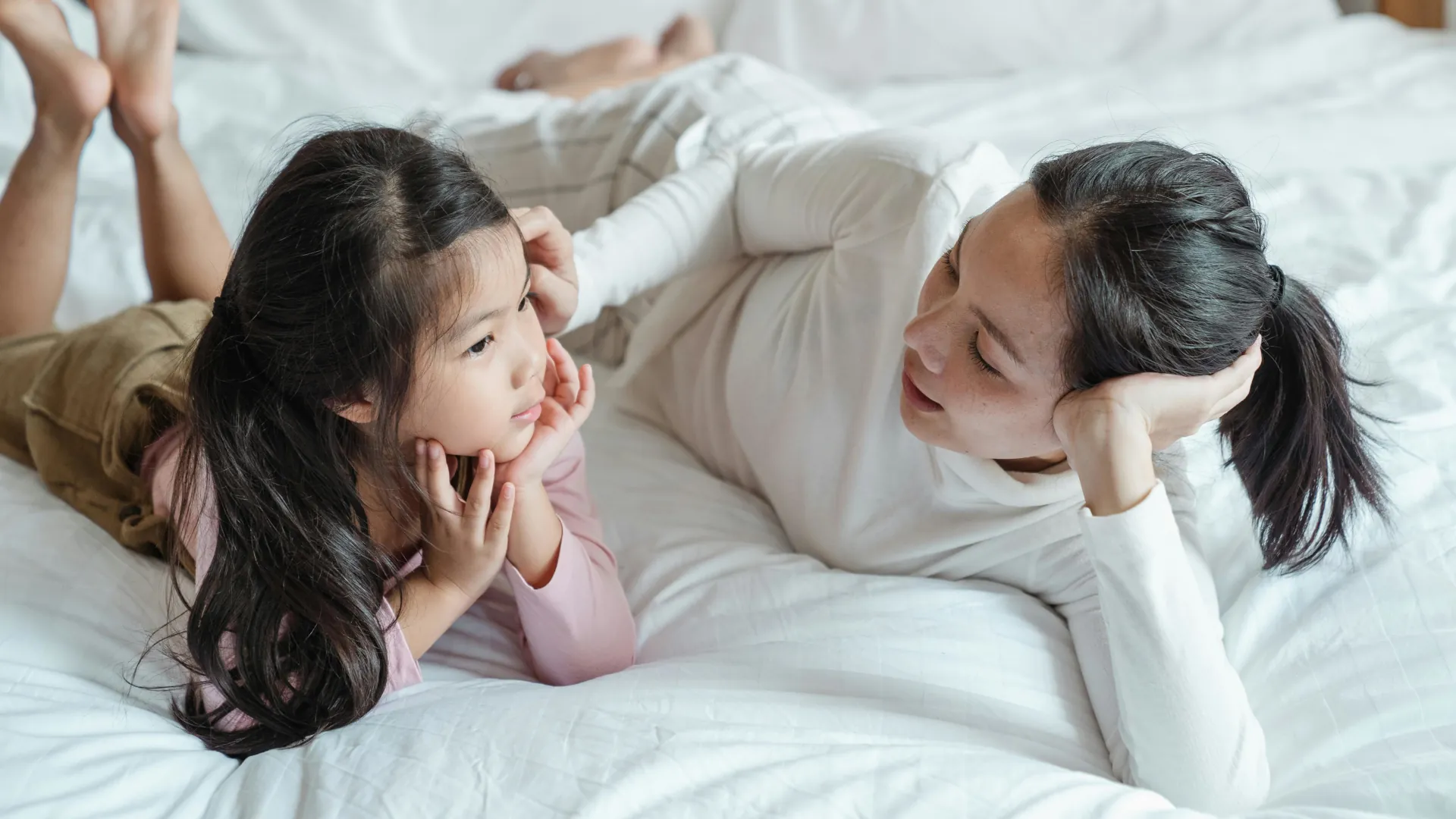 A specialist child counsellor is having a chat with a young girl about life. The young girl is quietly listening.
