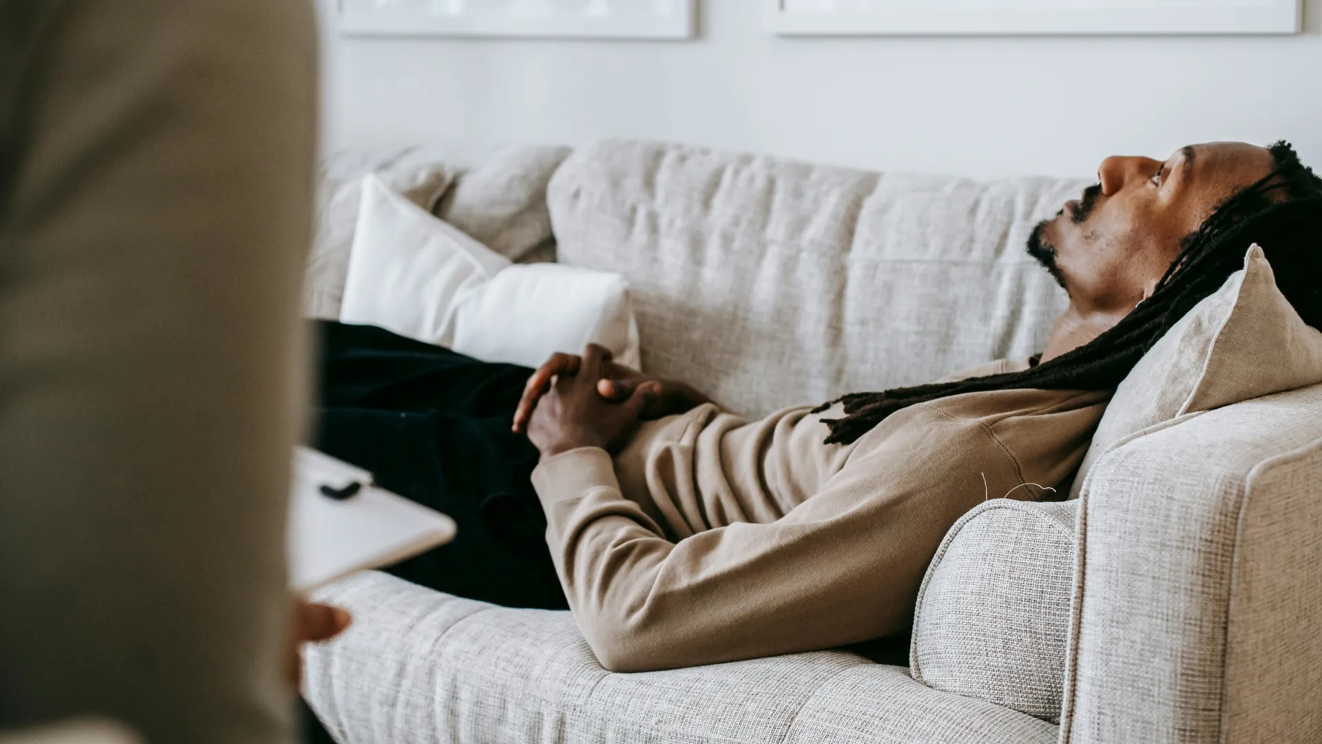 A young man relaxes on a couch and unloads his feelings and thoughts to his therapist.