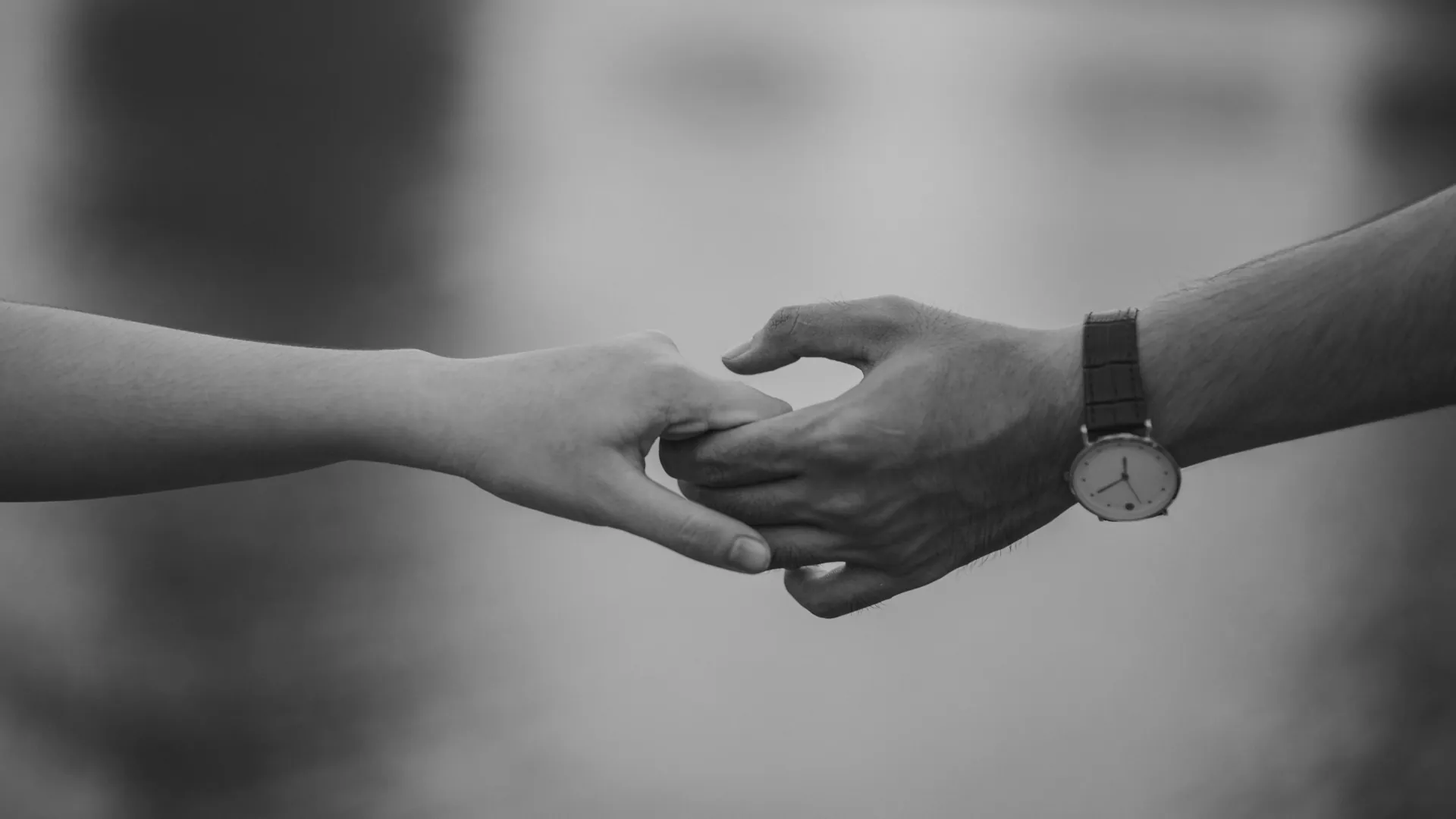 A couple embrace each others hands while they are attending relationship counselling.